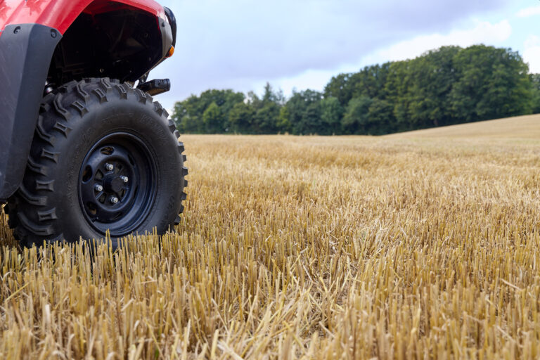 KENDA Bear Claw tire on Honda ATV in crop field