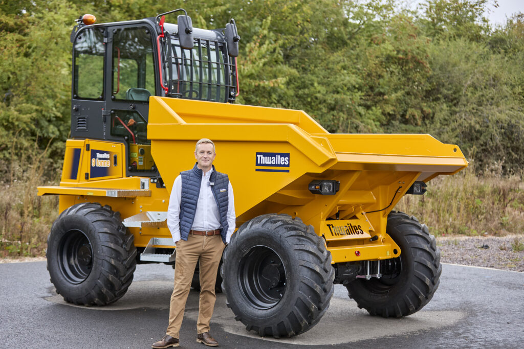 Sales representative from Thwaites standing in front of a dumper