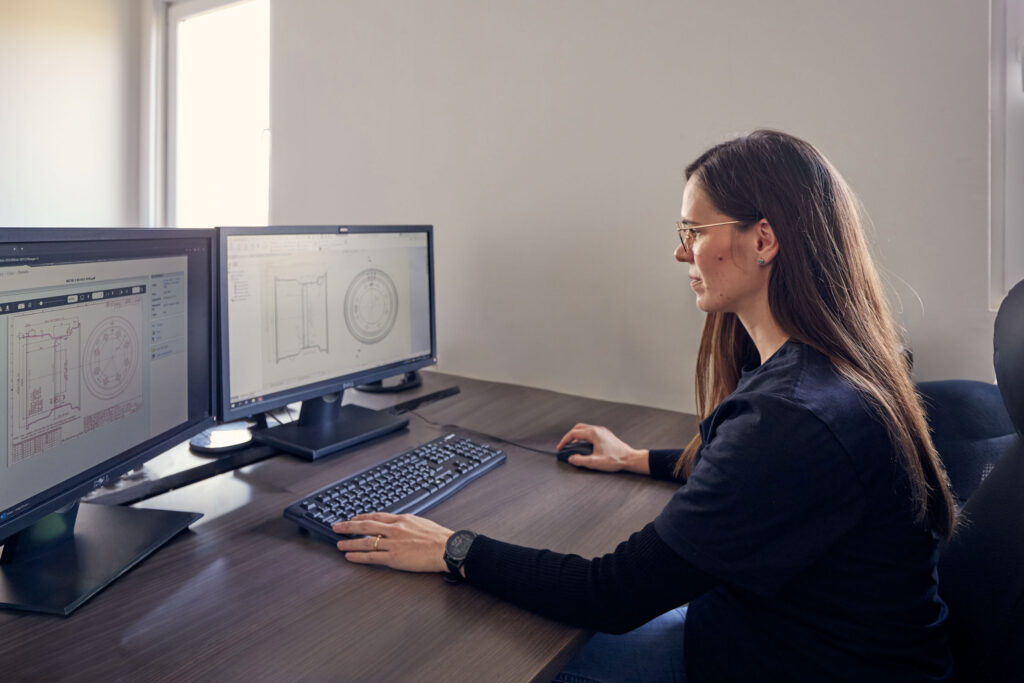 Engineer looking at technical drawing of steel wheels on a PC screen