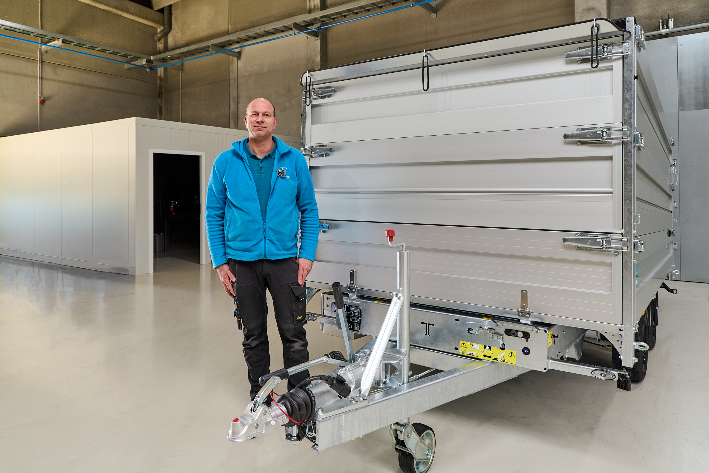 Founder and general manager at TwinTrailer Stefan De Rycke standing in front of one of their trailer and smiling